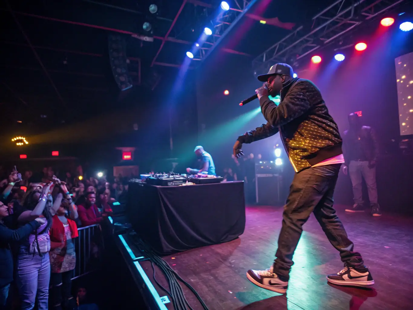 A group of Hip-Hop artists are performing live on stage at a HOLYJUICE ARTWORKS-organized event. The stage is vibrant and energetic, with a diverse audience enjoying the performance.